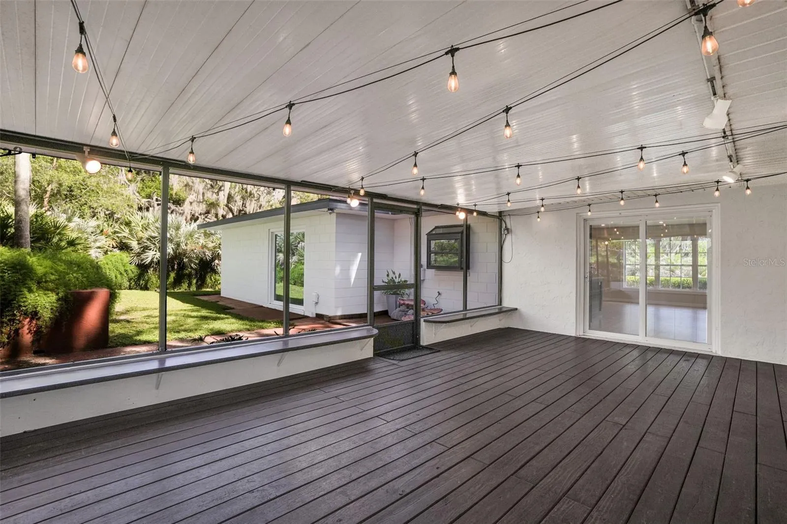 Expansive screened-in patio with real wood flooring, creating the perfect space for entertaining and relaxing.