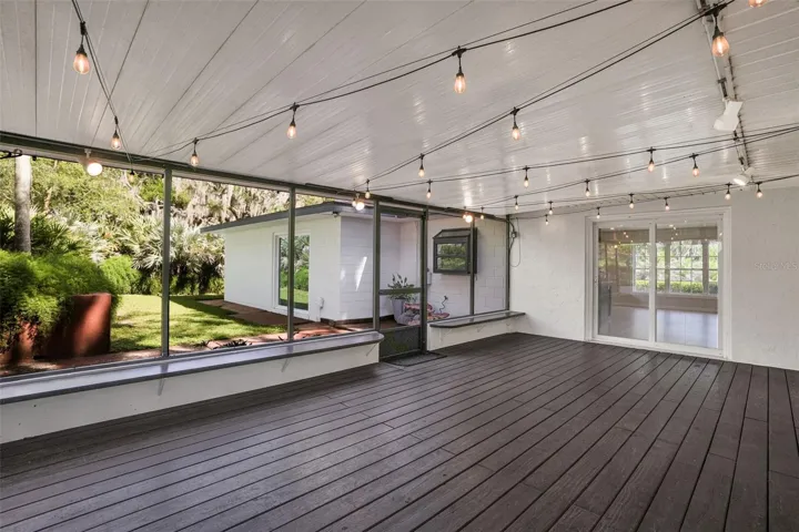 Expansive screened-in patio with real wood flooring, creating the perfect space for entertaining and relaxing.