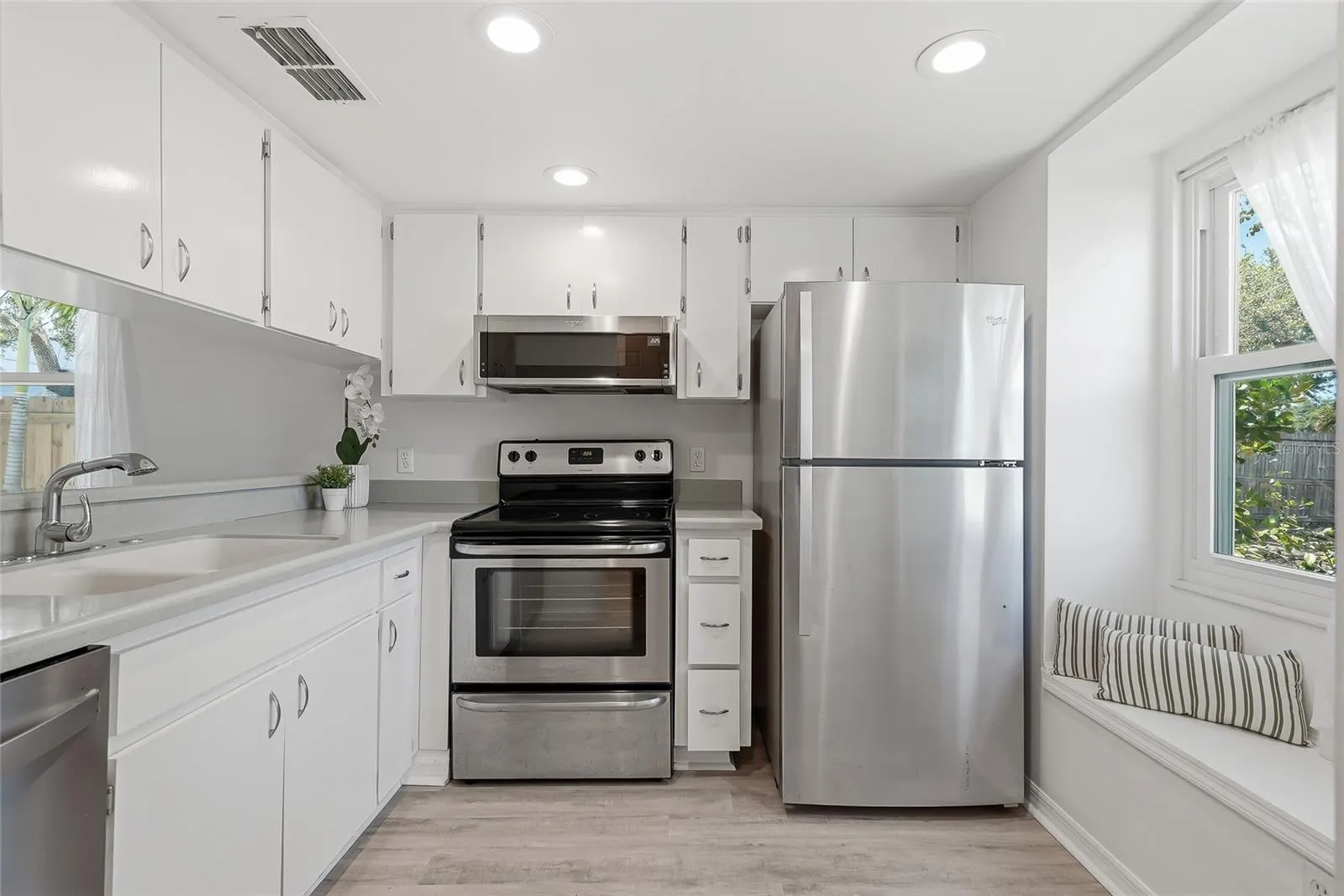 Greeted by a bright kitchen with a seating bench.