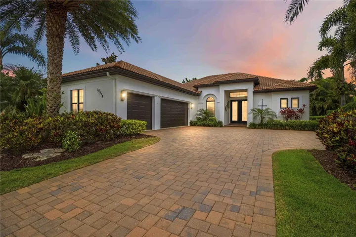 The approach from the street. Polished landscaping, clean lines, and a presence that earns its price tag before you even open the door.