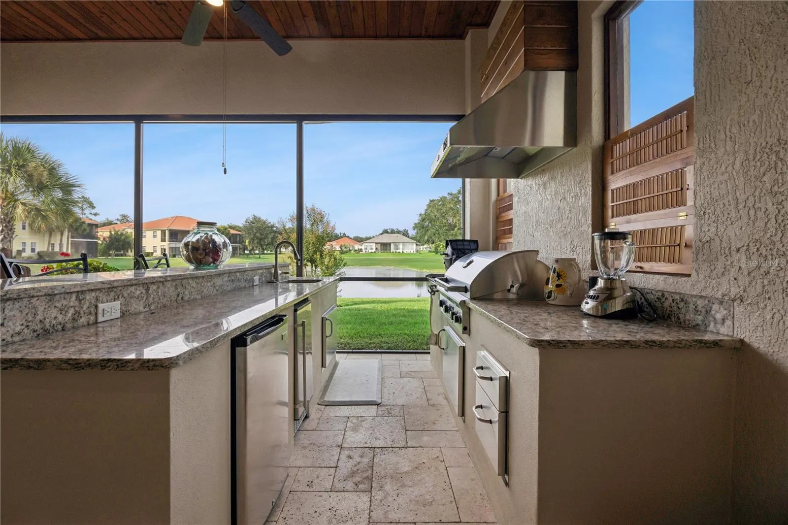 Sink, gas grill & small refrigerator.  Beautiful view of the pond.