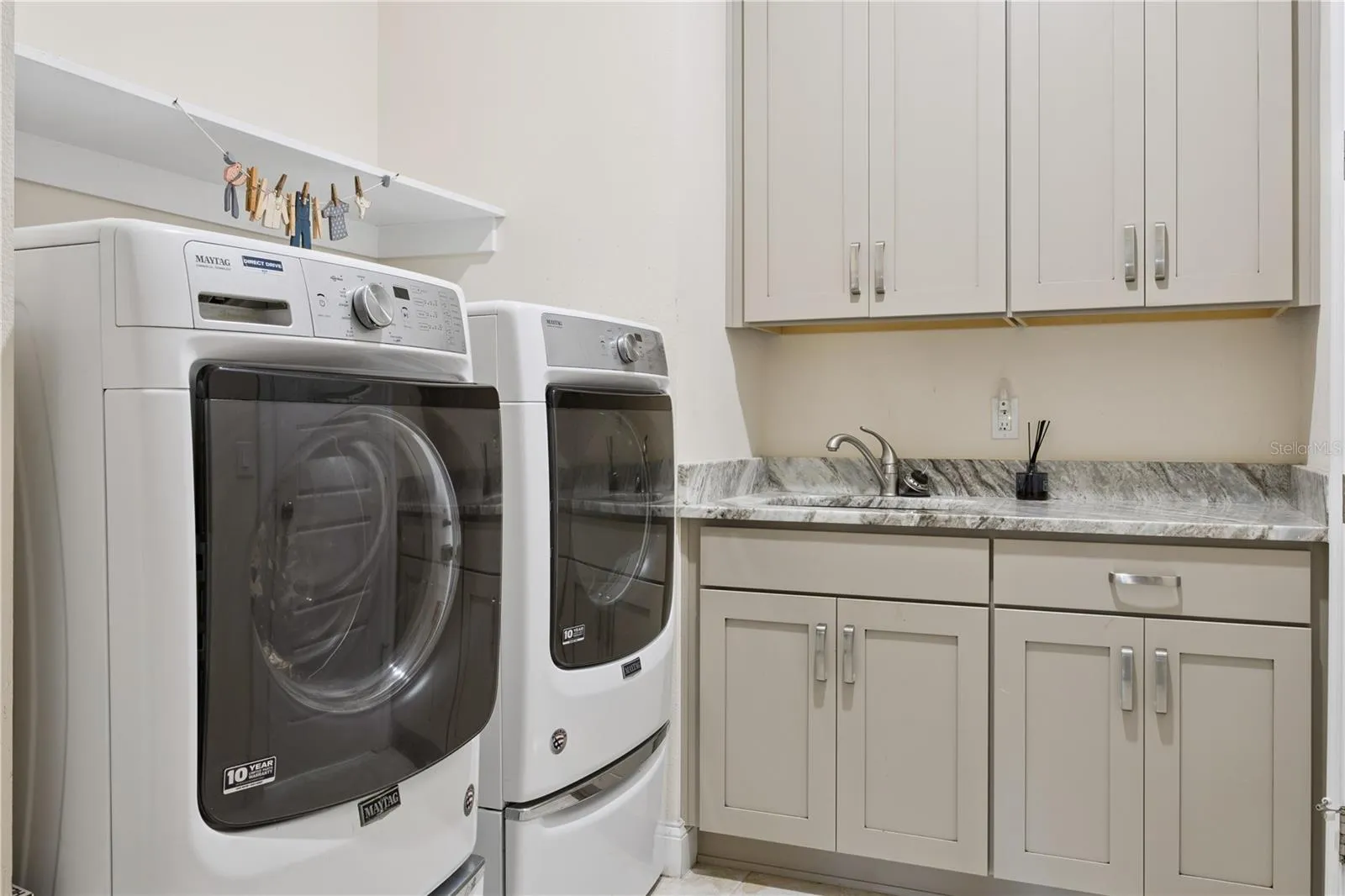 Laundry with sink, custom, cabinets, granite countertops, washer & dryer.
