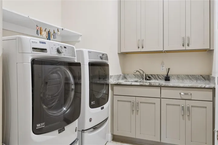 Laundry with sink, custom, cabinets, granite countertops, washer & dryer.