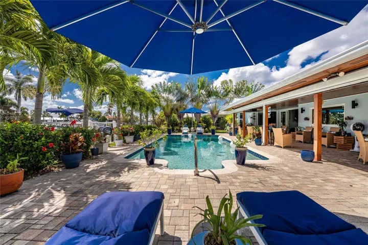 Lush tropical landscaping — towering traveller and christmas palms, vivid blooms, and layers of green that make every corner feel like a private resort.