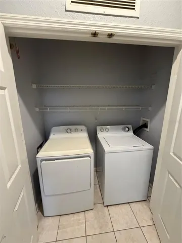 Entryway laundry closet with storage shelf