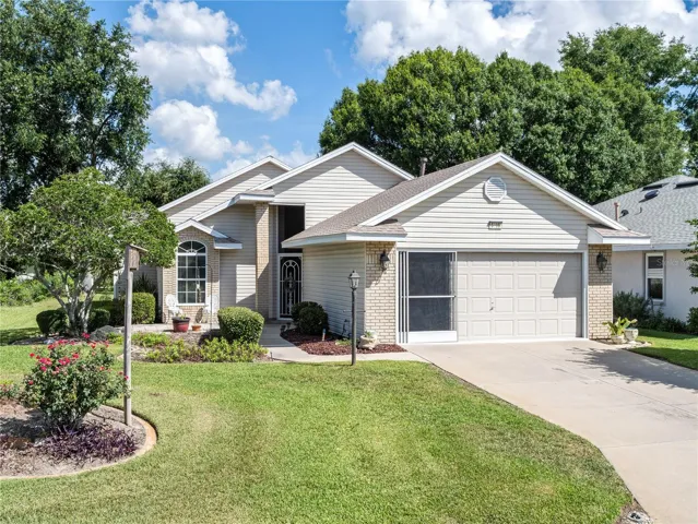 Florida landscape leads to front sitting area and screened front porch.