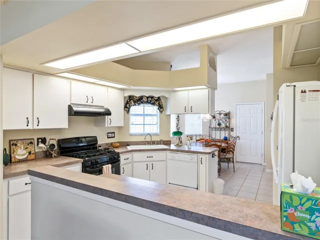Very bright kitchen with lots of cabinets, counter space, and gas stove.