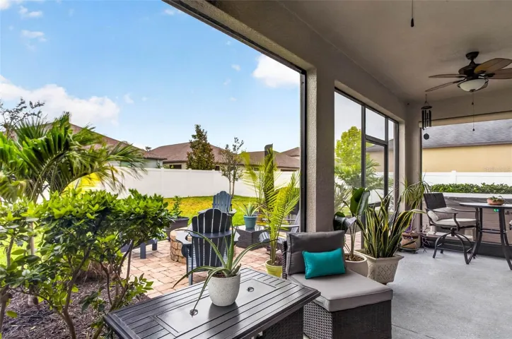 Screened lanai overlooks extended pavered area with firepit.