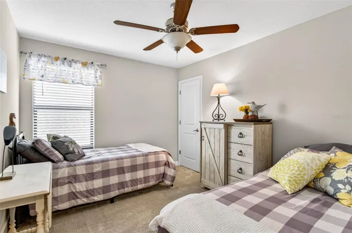Upstairs bedroom with built in closet, ceiling fan and blinds