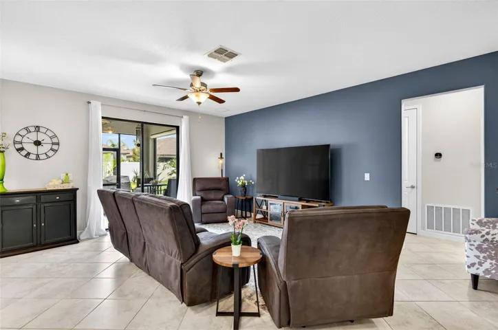 Main Living area with ceiling fan and sliding doors on to covered lanai