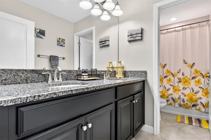 Upstairs bathroom with dual sinks and private/separate wash closet/shower area.
