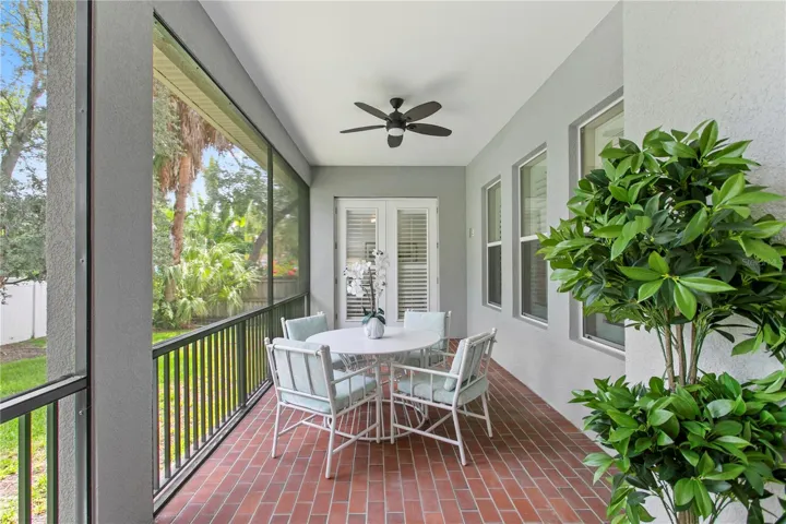 A door opens to the screened lanai, seamlessly extending your living space outdoors and creating the ideal setting for morning coffee, weekend barbecues, or relaxing evenings overlooking the backyard