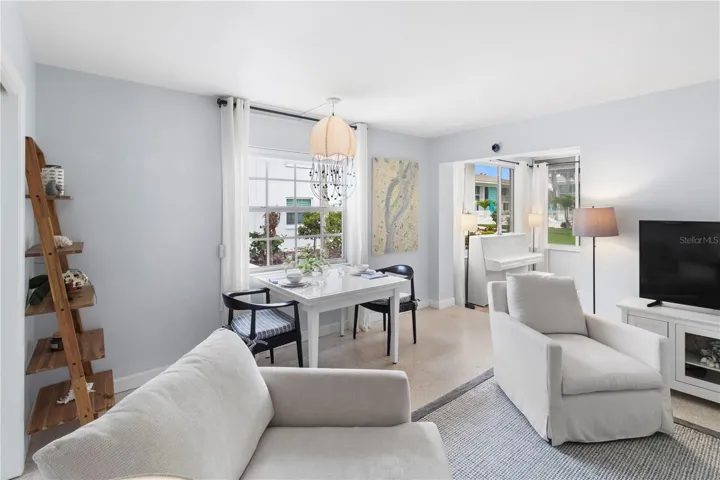 View of dining area and sun room (piano not included) from living room