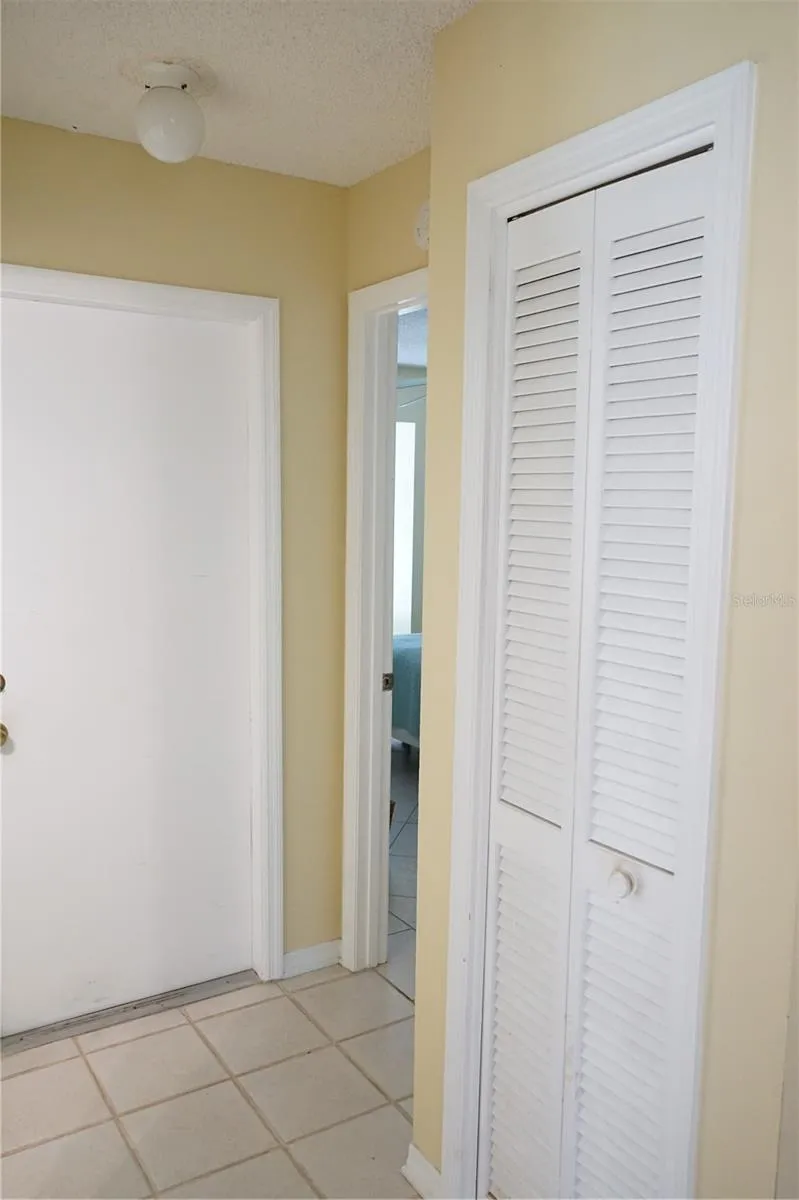 hall closet and door to guest area and garage