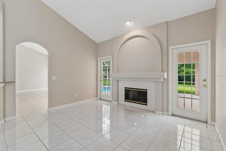 Gathering Room with fireplace and French doors to lanai and pool