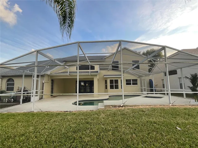 View of Back of 5 bedroom, 2.5 bathroom plus an office, 2 -car garage. POOL and Pond frontage