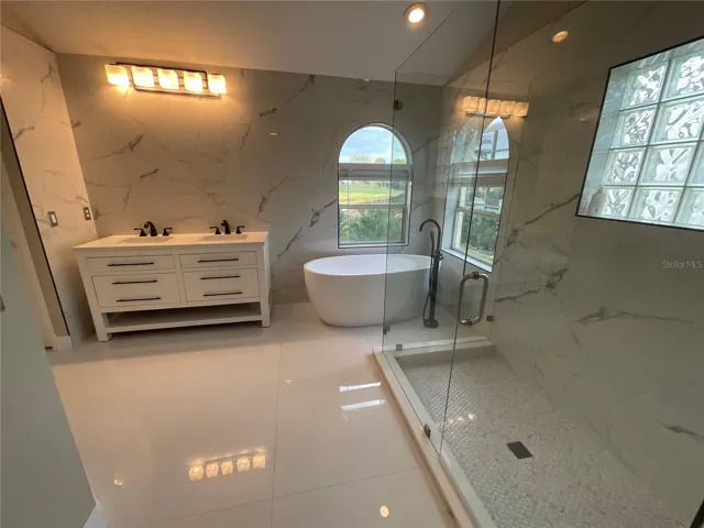 Primary Bathroom with large shower, freestanding tub, toilet closet, dual sink vanity and his and hers walk-in closets.
