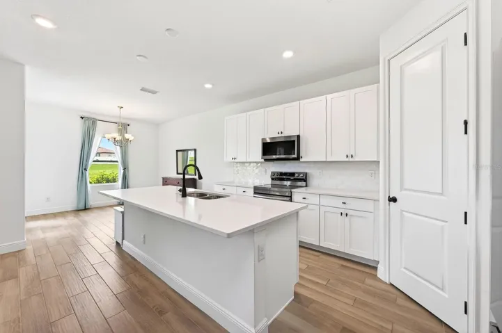 The upgraded kitchen is the heart of the home, featuring enhanced STAINLESS STEEL APPLIANCES, ample cabinetry, generous counter space, and seamless connectivity to the living and dining areas.