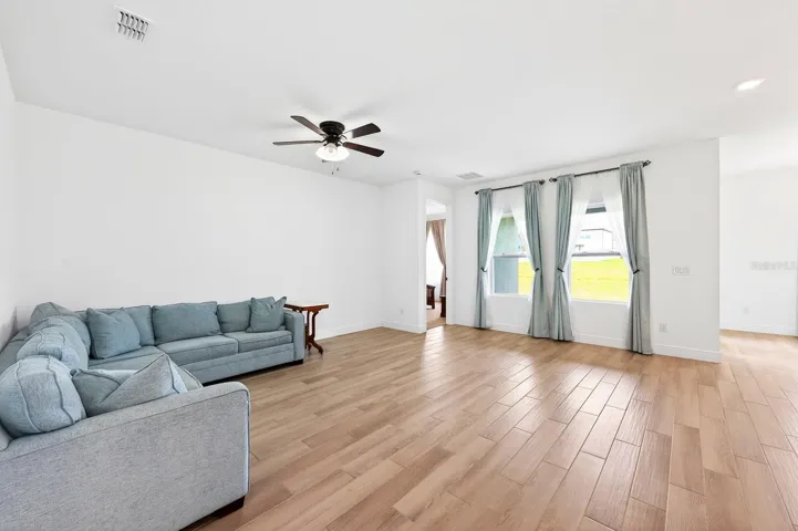 Inside, high ceilings and abundant natural light enhance the spacious open living, dining, and kitchen areas, creating a bright and inviting atmosphere ideal for everyday living or entertaining family and friends.