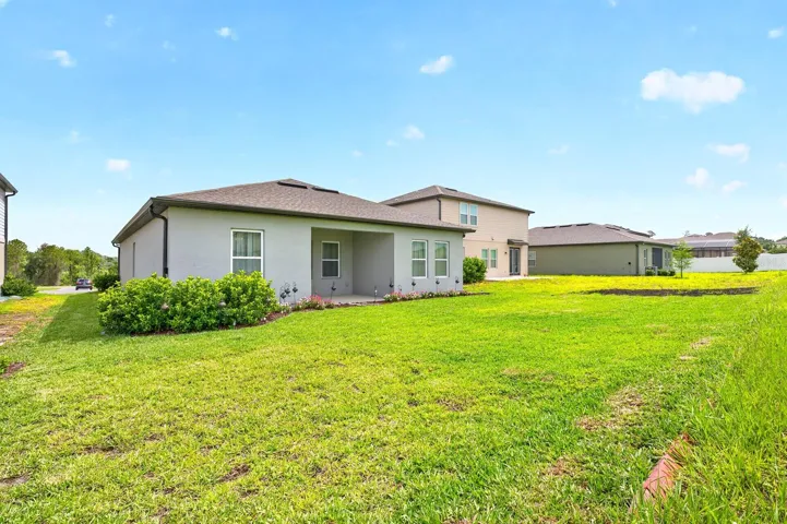 Covered lanai overlooks a nice backyard.