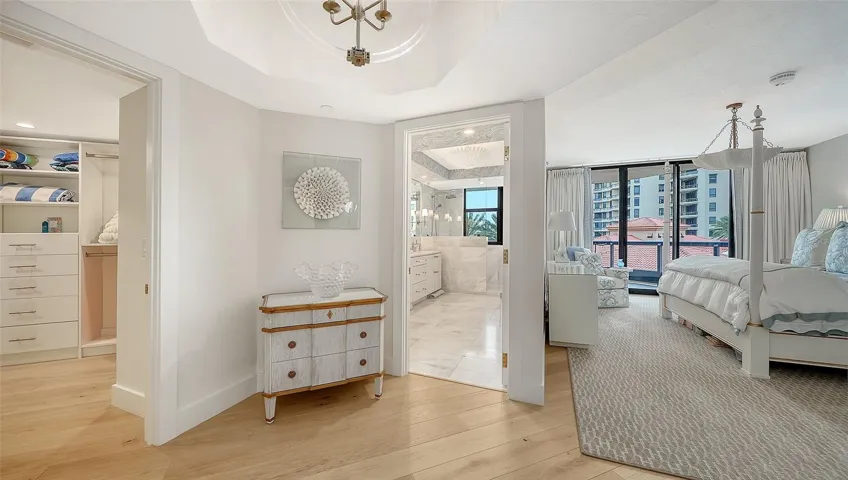 A Welcoming vestibule is  an elegant transition for the primary suite separating the sumptuous bedroom from the private bath and generous walk in closet w/ gorgeous fixtures galore !
