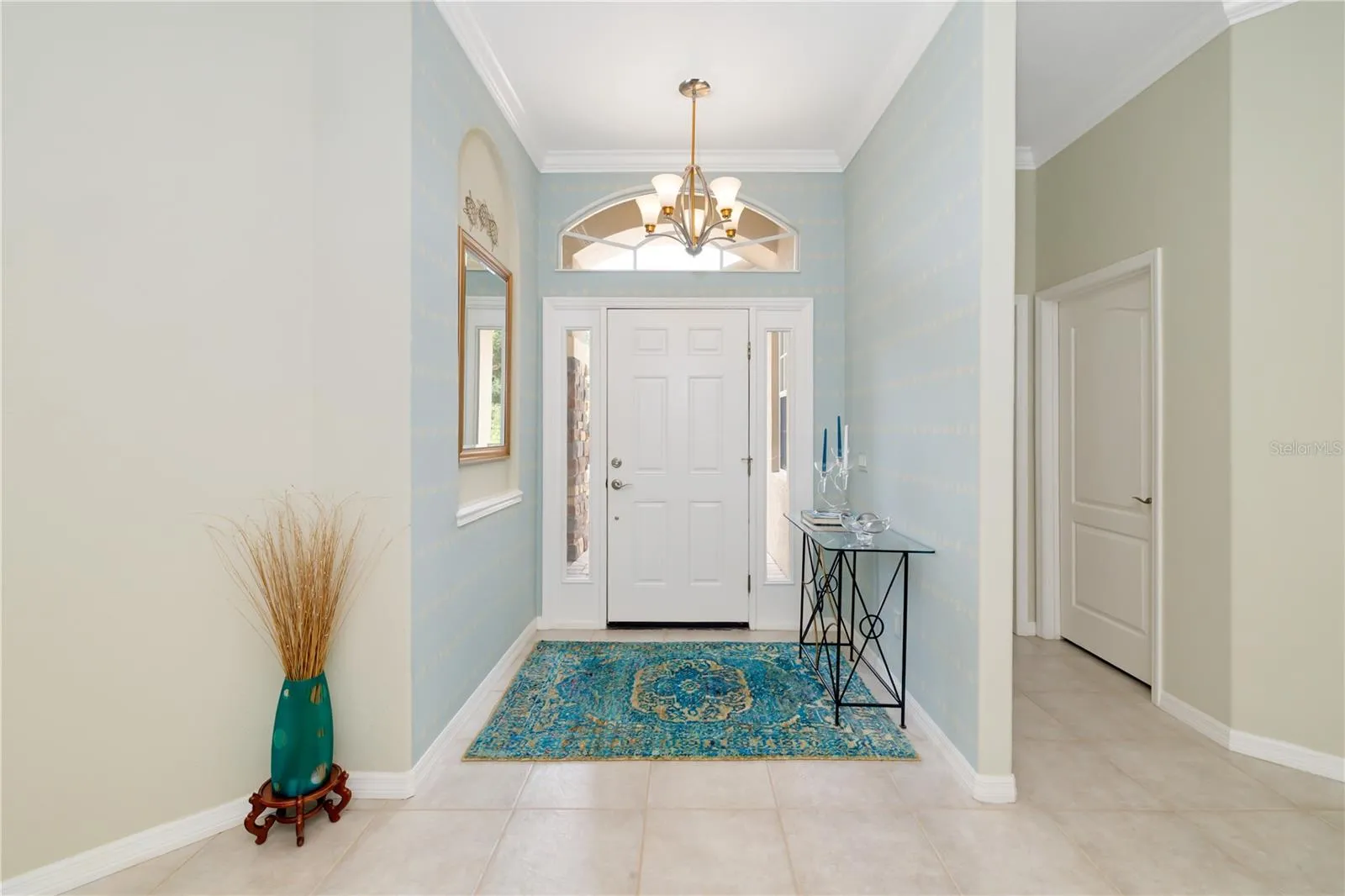 Beautiful, light, bright foyer with crown molding, trey ceiling, modern lighting, welcoming you to the modern updated 5 bedroom heated pool home at 12471 Natureview Circle
