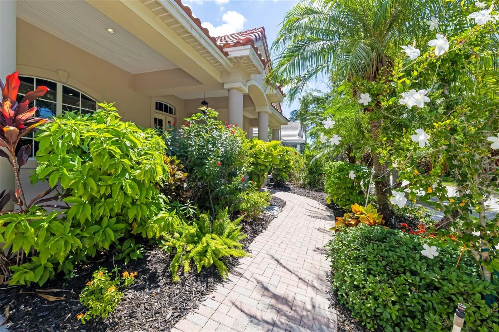 Lush tropical Florida Landscaping, creating a serene tranquil inviting private residence at Harbour Walk at The Inlets