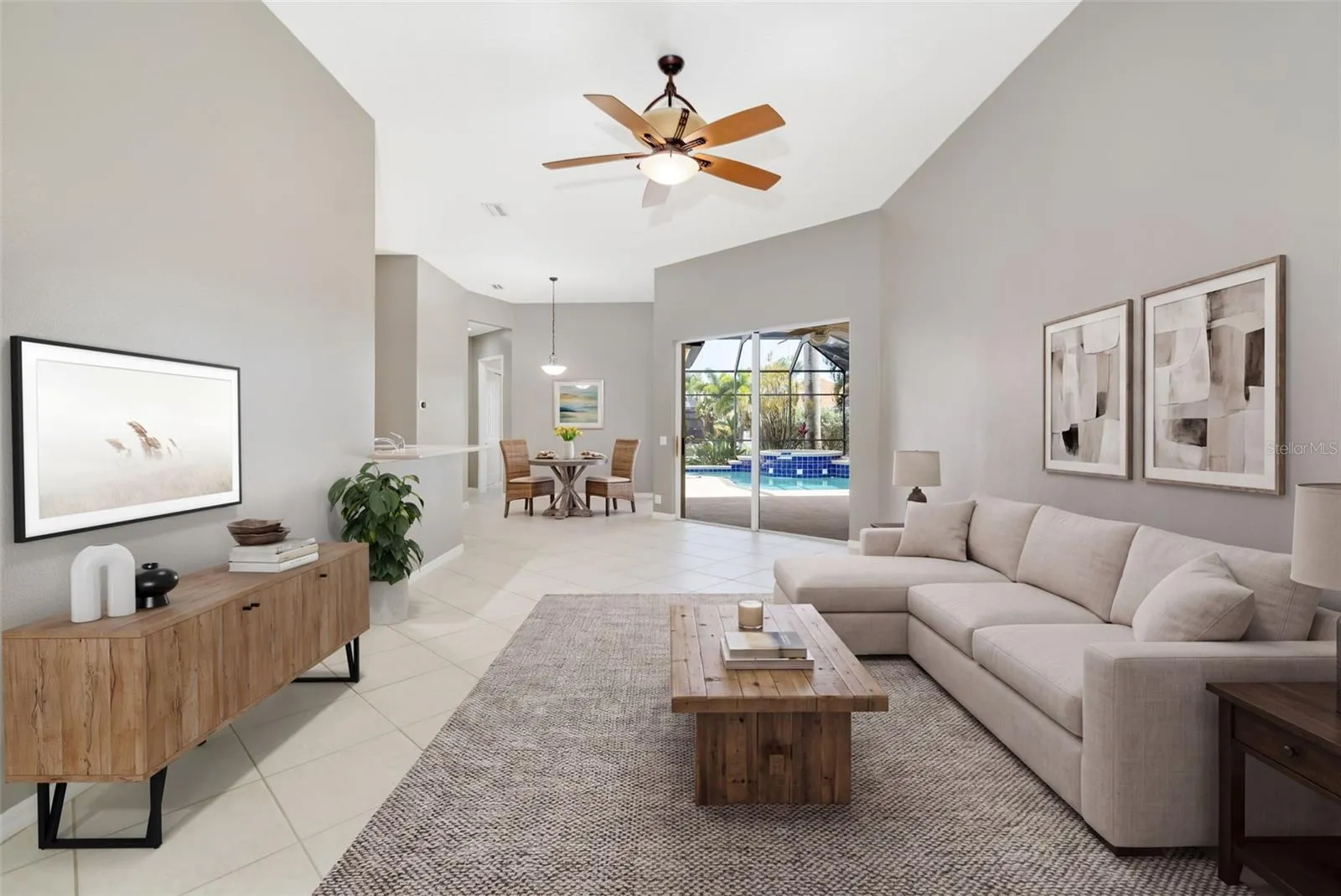 Living room with two sliding glass door entrances to lanai, pool with separate casual eating space