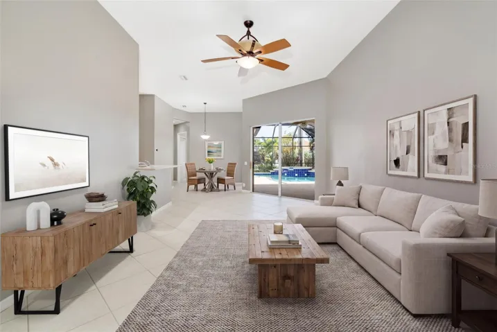 Living room with two sliding glass door entrances to lanai, pool with separate casual eating space