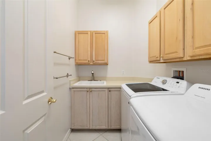 Interior laundry room, utility sink and storage cabinets, washer and dryer