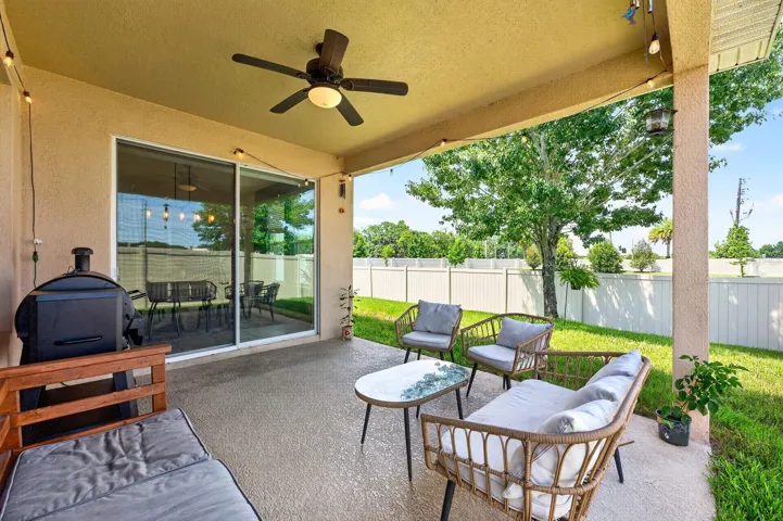 Covered lanai overlooks a fenced backyard.