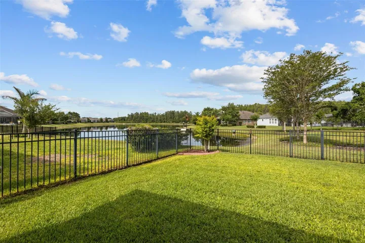 Fenced backyard with serene pond views
