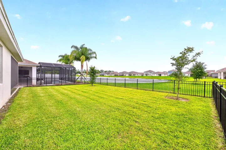 Fully fenced back yard has pond views.