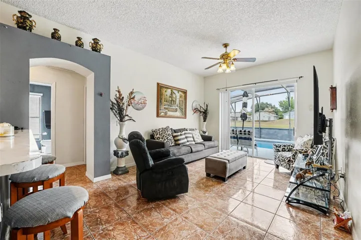 View from the kitchen looking into the family room with a clear sightline to the screened-in pool.