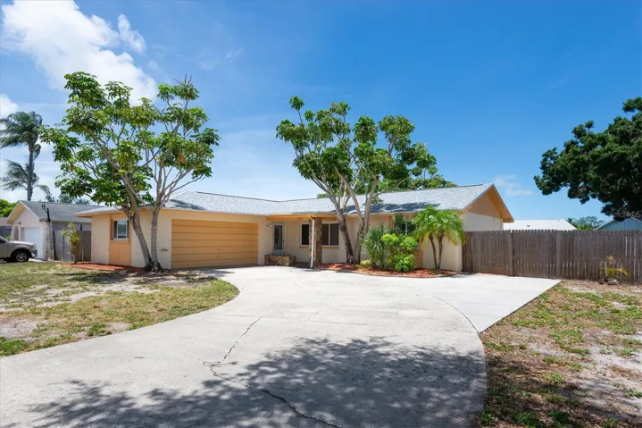 Front Exterior - Driveway with gate to backyard and room to park behind the fence