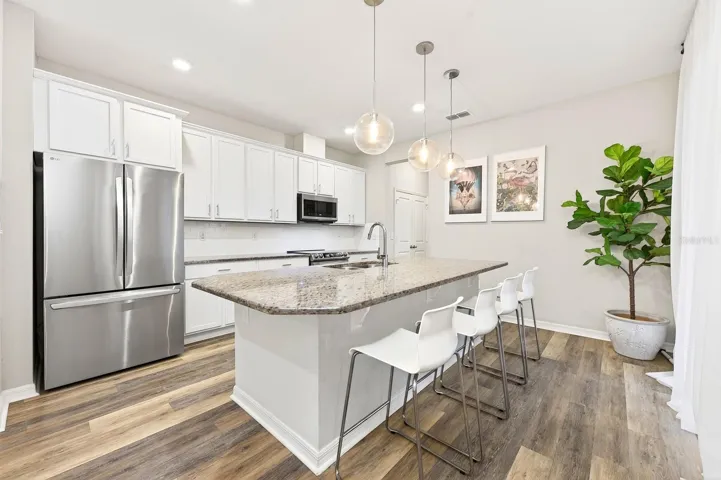 With room for counter-height seating, the Kitchen island doubles as a comfortable spot for quick meals or gathering with guests.