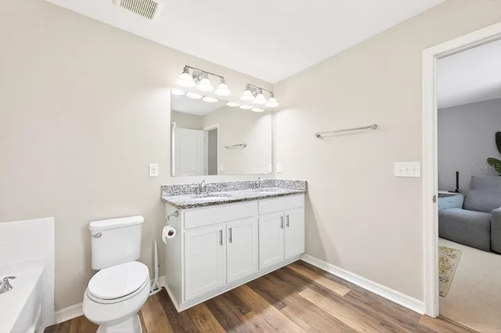 A STYLISH EN SUITE BATH boasts dual sinks, a garden tub, and a separate step-in shower.