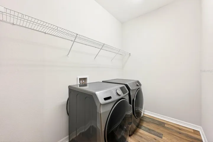 The Laundry Room includes a washer, dryer and shelving for storing supplies.