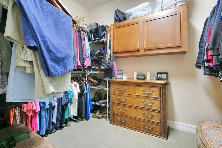Owner's Closet with cabinet to pass through clothes to the laundry room