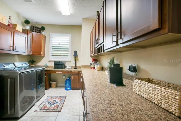 Oversized laundry room with cabinets and desk space