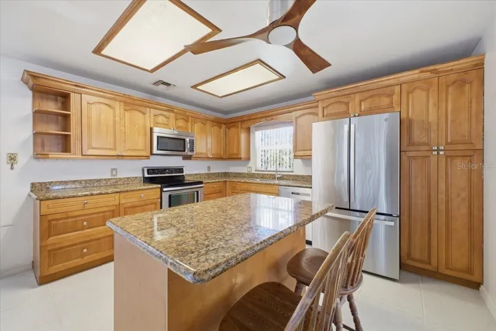Kitchen with all stainless steel appliances, wood cabinets and granite countertops