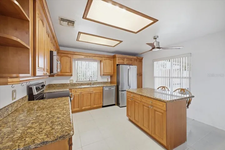 Kitchen with all stainless steel appliances, wood cabinets and granite countertops