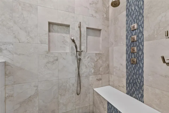 Designer walk-in shower with waterfall tile accent and premium multi-jet shower system