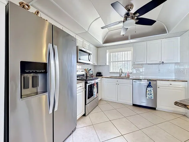 Modern coastal charm kitchen with tile floors, sleek finishes, and a layout that flows endlessly for entertaining.