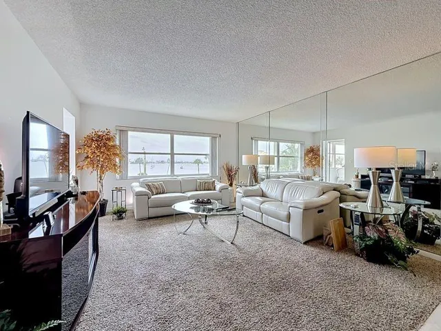Open and airy living area that flows effortlessly from the dining room, highlighted by contemporary decor and warm sunlight and a serene view.