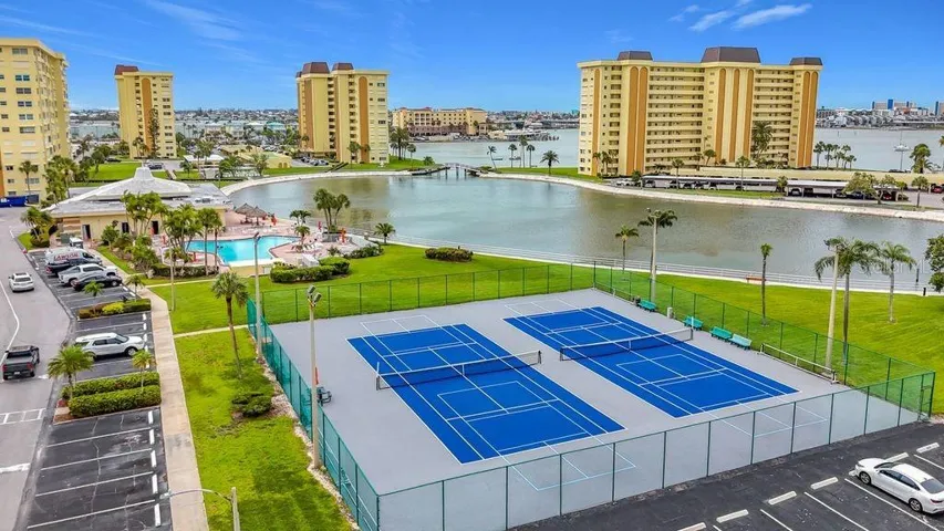 Resort-style community view featuring the Washington building, tennis and pickleball courts, and sparkling pool- all nestled around the tranquil bayou