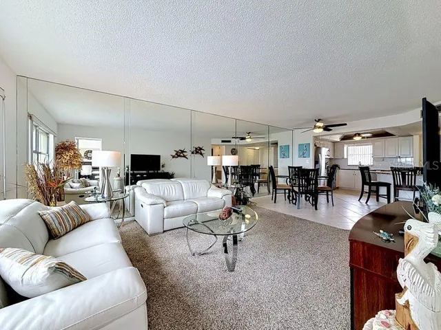 Open and airy living area that flows effortlessly from the dining room, highlighted by contemporary decor and warm sunlight and a serene view.