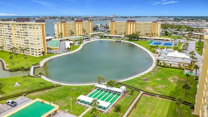 Resort-style community view featuring the Washington building, tennis and pickleball courts, and sparkling pool- all nestled around the tranquil bayou