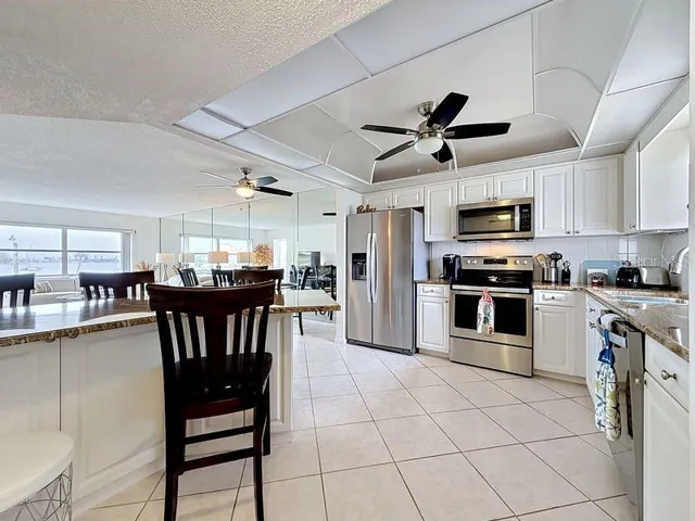 As you enter, you will see the spacious chef's kitchen with gleaming stainless steel appliances, crisp white cabinetry, and a breakfast nook bathed in natural light.