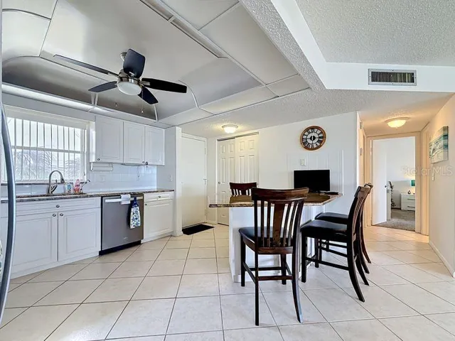 Modern coastal charm kitchen with tile floors, sleek finishes, and a layout that flows endlessly for entertaining.